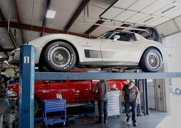A classic Chevrolet Corvette on a lift at a transmission shop in Springfield MO.