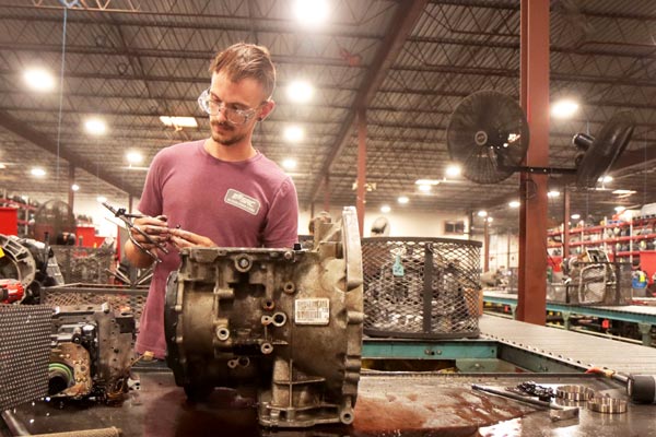 A man rebuilding a transmission in a Springfield MO factory