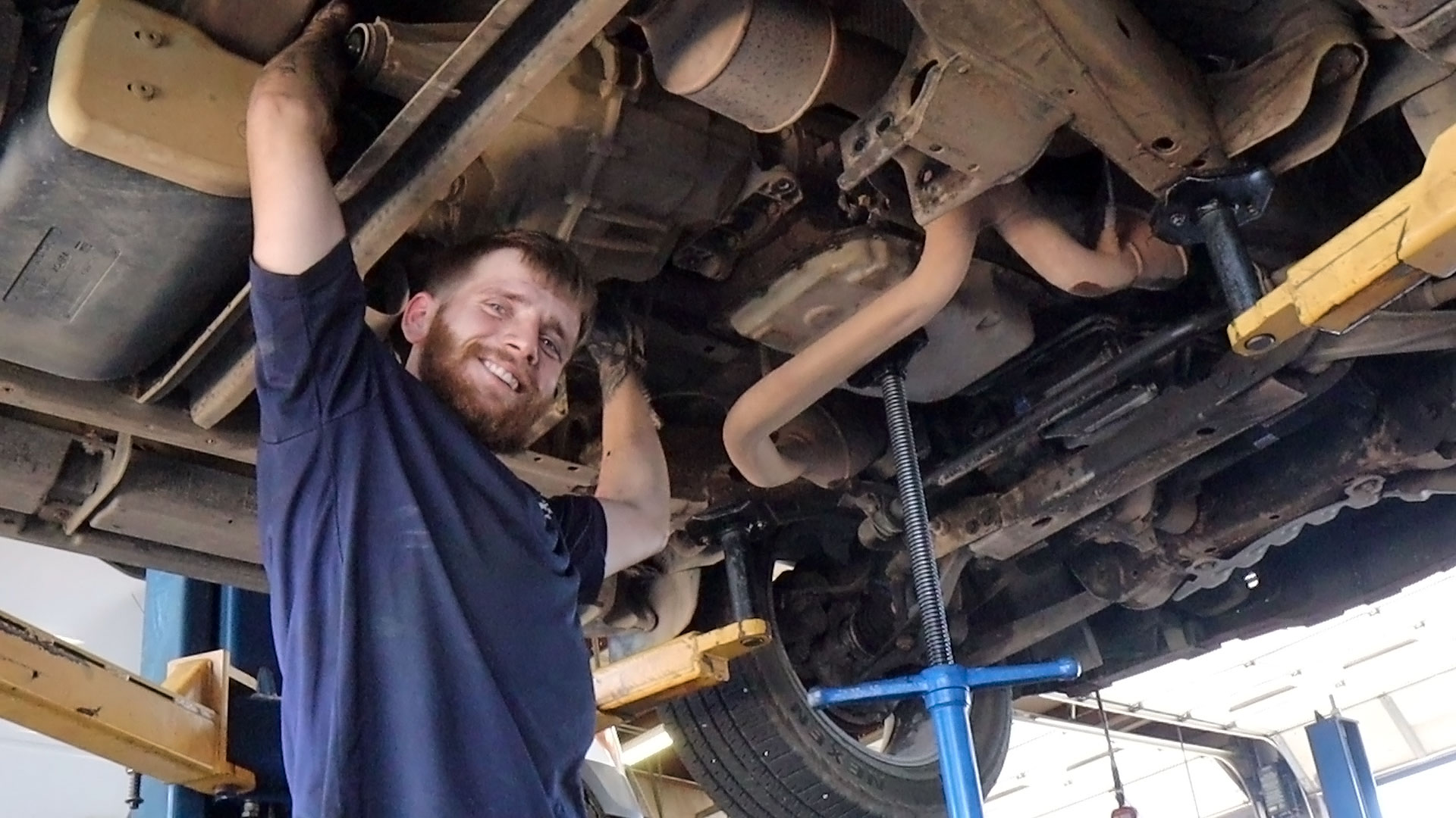 A smiling transmission technician installing a remanufactured unit.